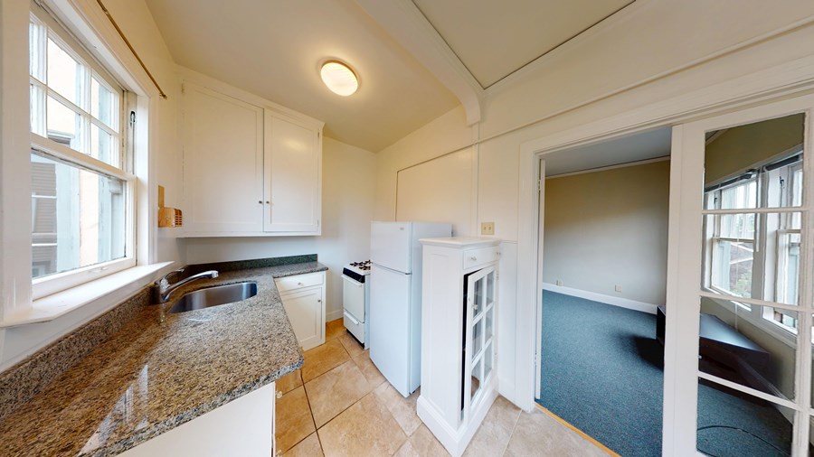 A kitchen with granite countertops and white cabinets.